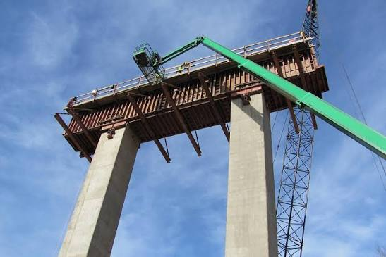 Bridge girder forming system spanning concrete piers